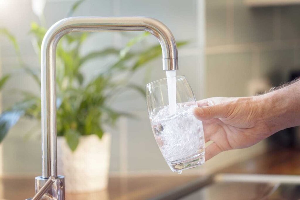 Person filling glass with water