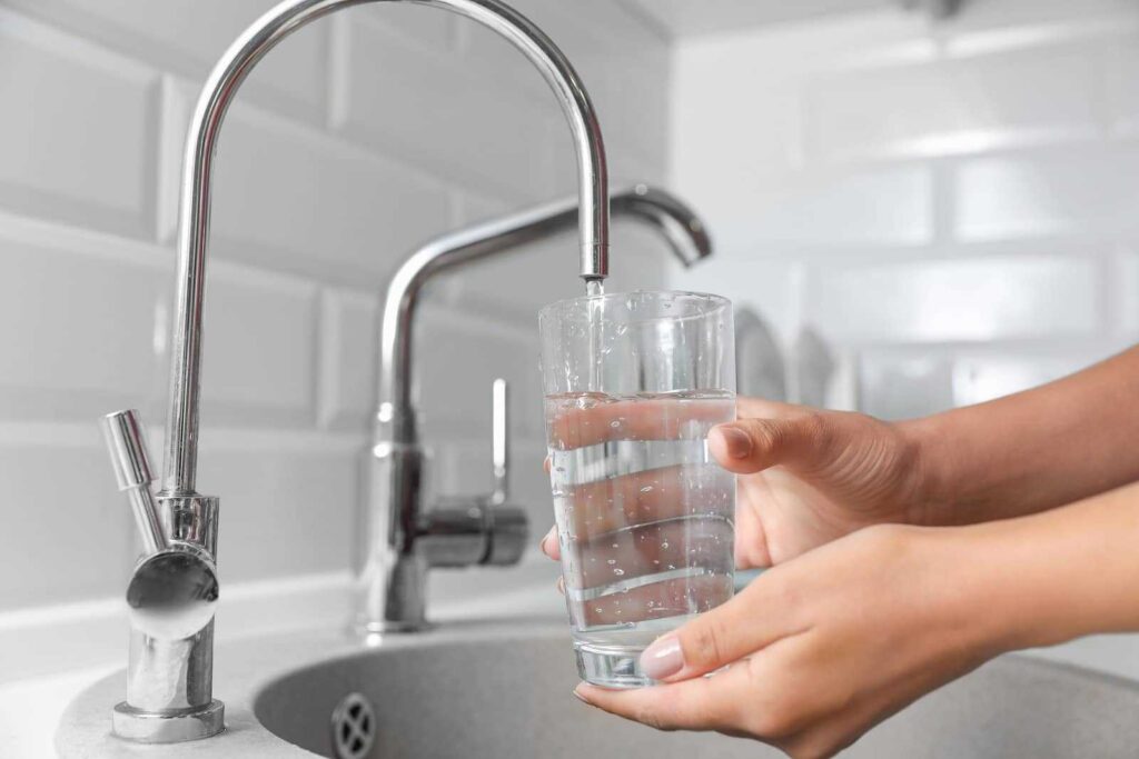 Person filling glass with water
