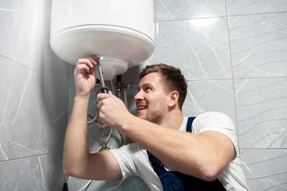 tech repairing water heater