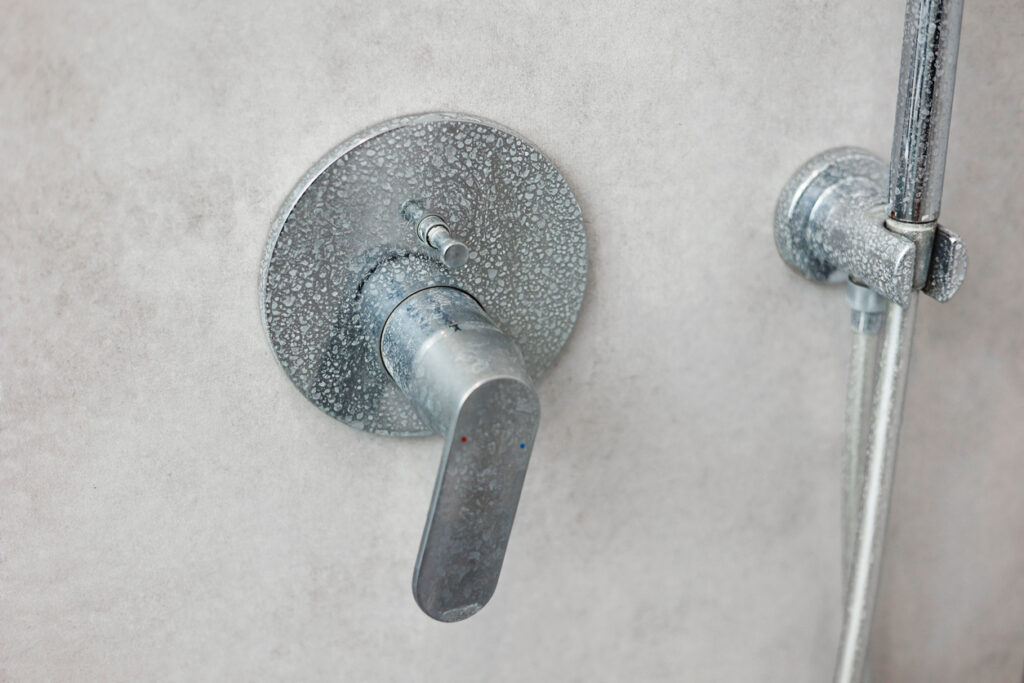 Dirty calcified shower mixer tap, faucet with limescale on it, plaque from hard water,