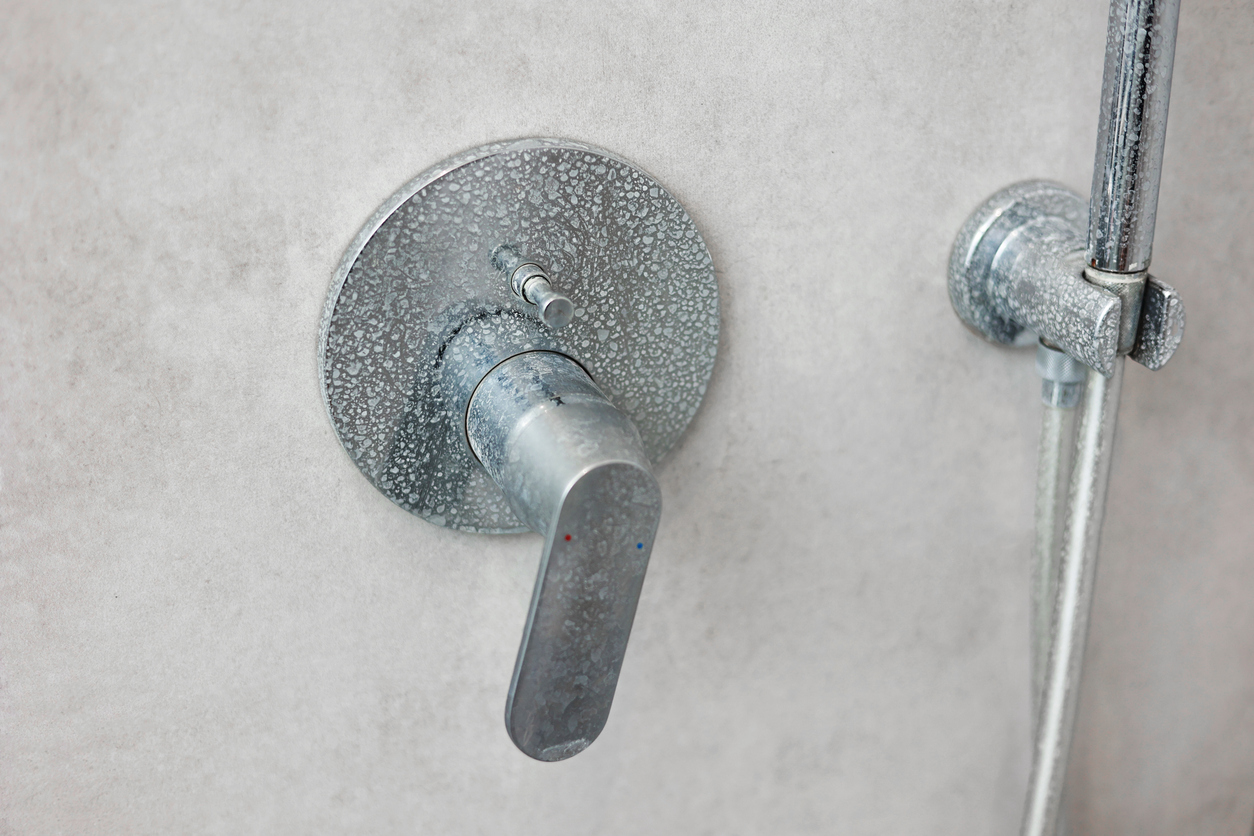 Dirty calcified shower mixer tap, faucet with limescale on it, plaque from hard water,